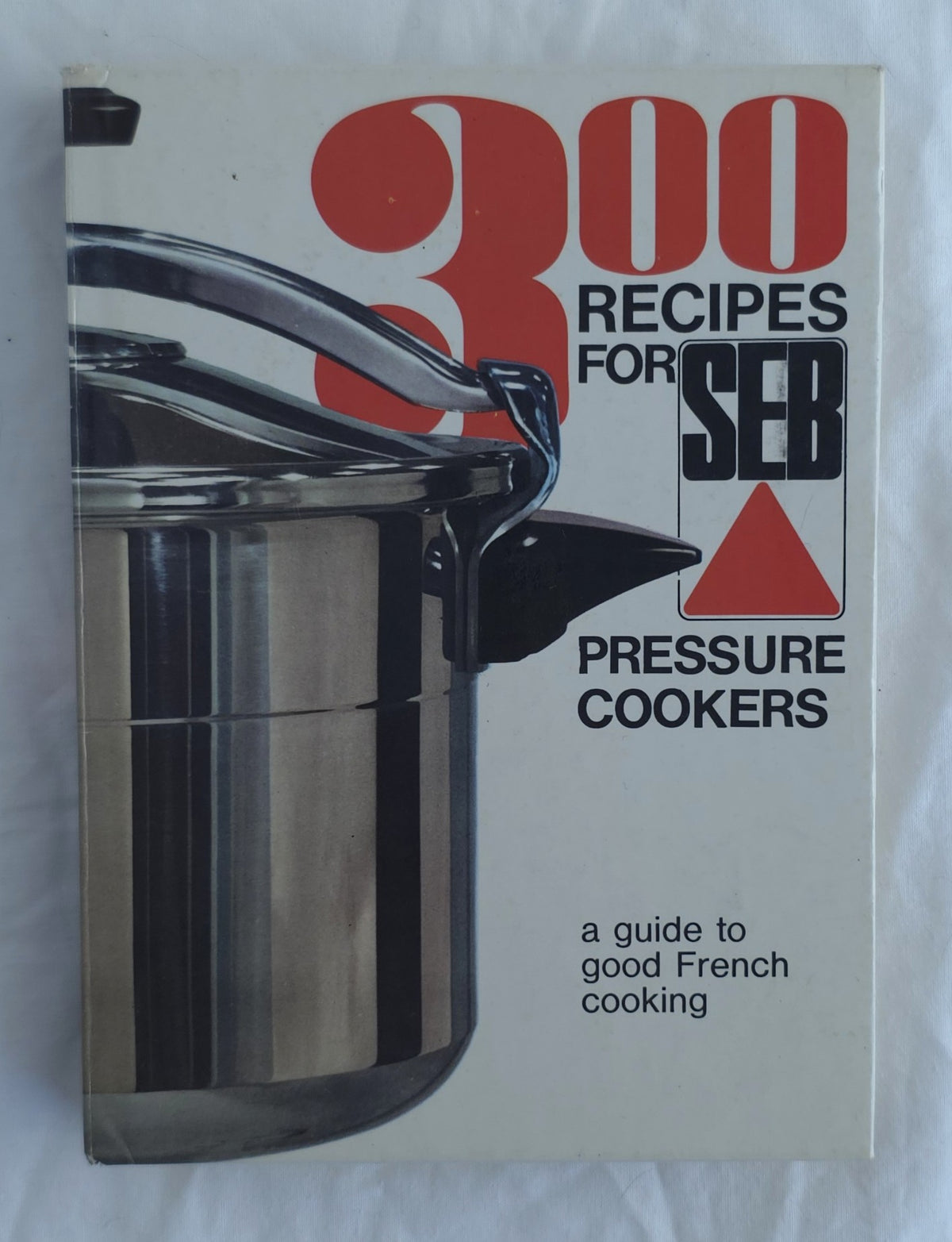 A vintage cookbook titled '300 Recipes for Seb Pressure Cookers' with a cover showing a stainless steel pressure cooker. The cover has a cream background with bold red and black text.
