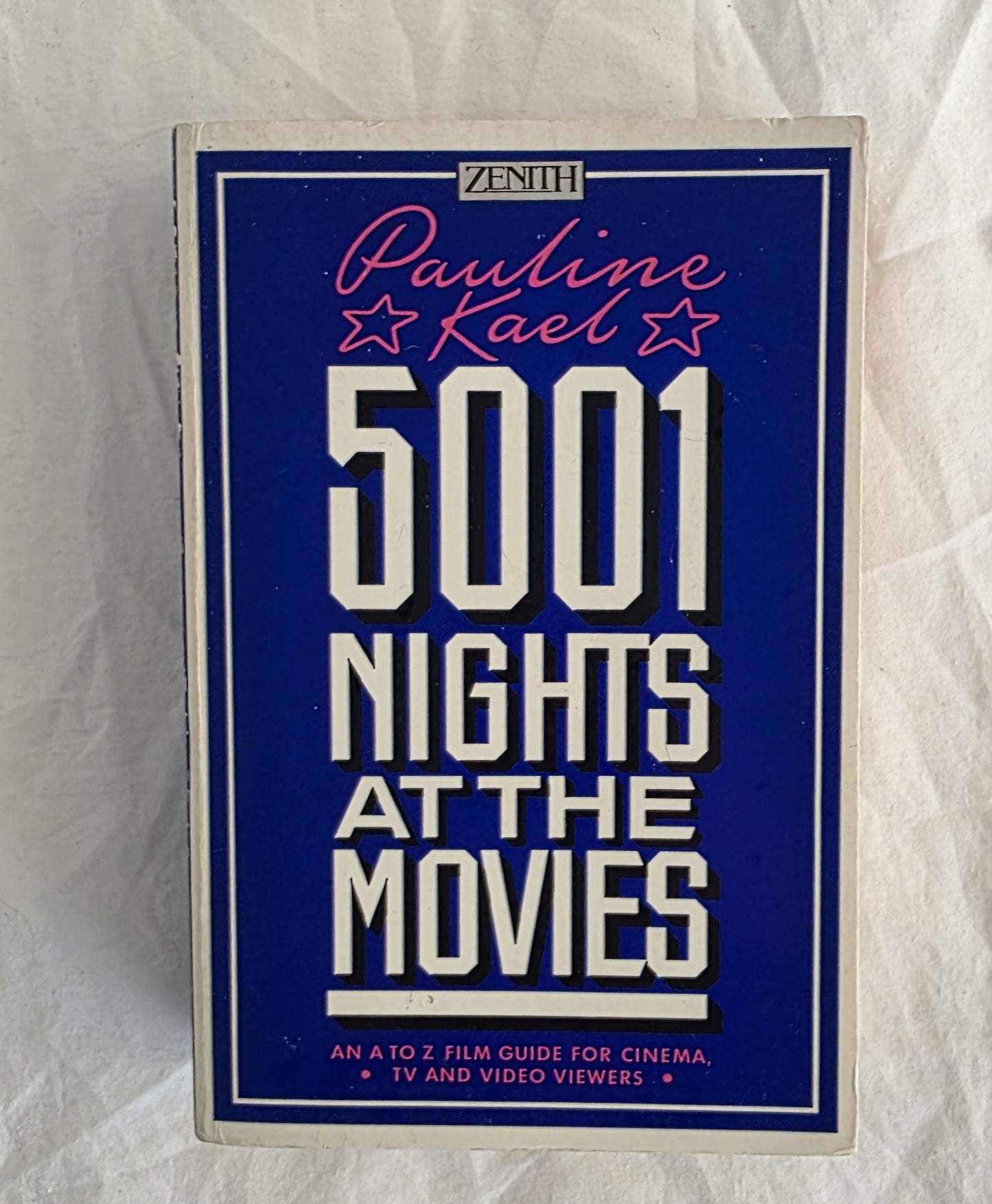 Book cover of '5001 Nights at the Movies' by Pauline Kael on a textured white background