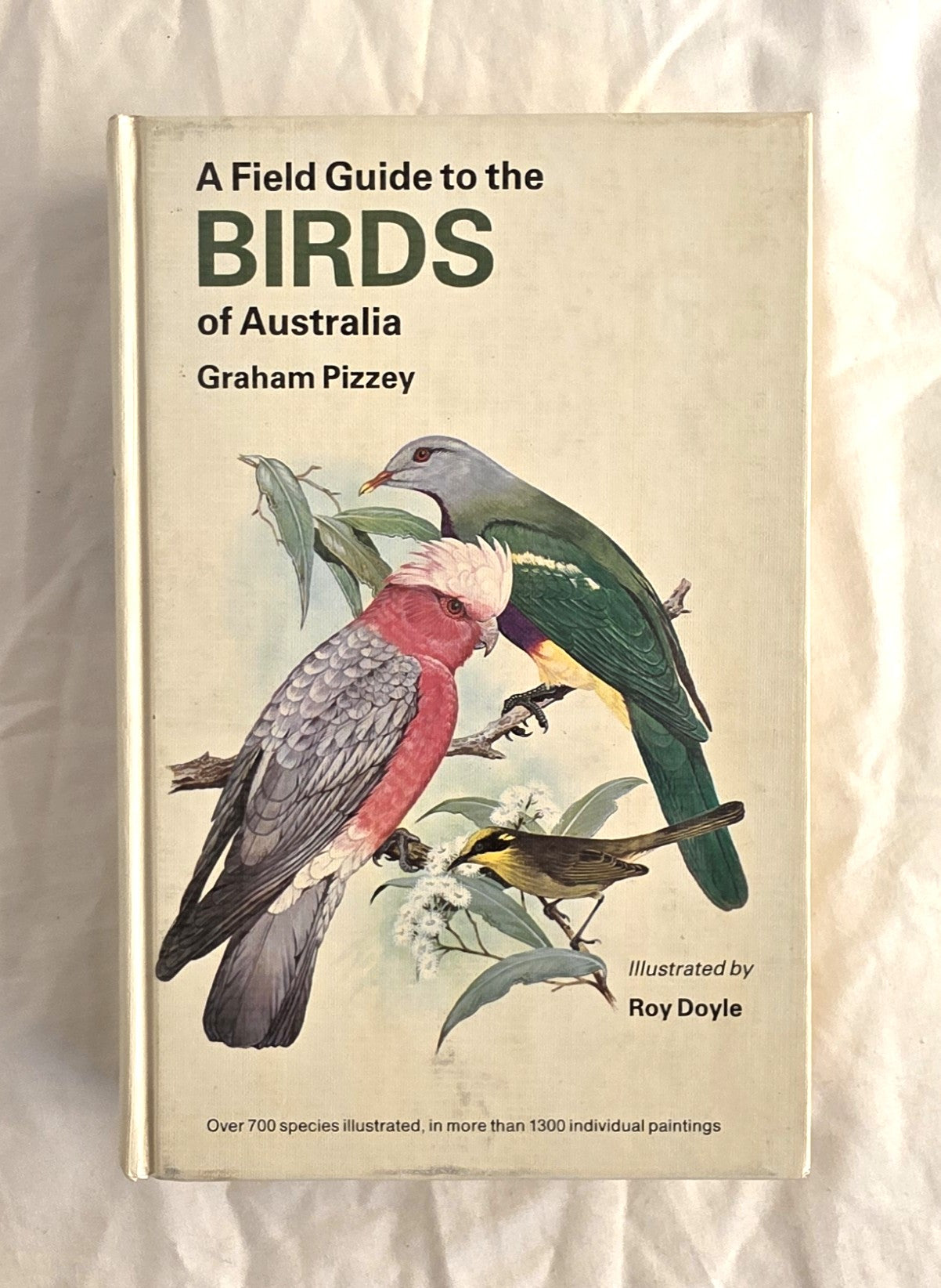 Book titled 'A Field Guide to the Birds of Australia' by Graham Pizzey on a textured beige background.