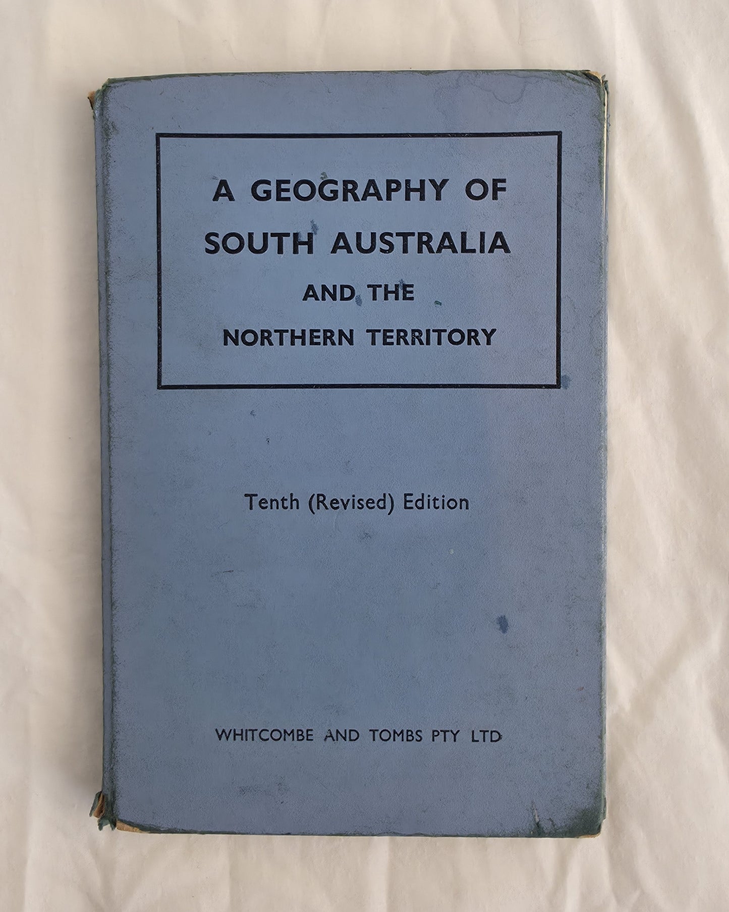 Blue book titled 'A Geography of South Australia and the Northern Territory' on a white background