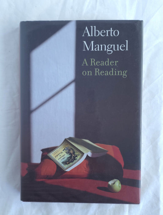 Book cover of 'A Reader on Reading' by Alberto Manguel with a blurred background