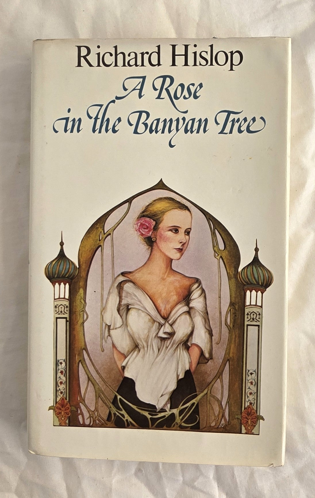 Book cover of 'A Rose in the Banyan Tree' by Richard Hislop with a woman's portrait and architectural elements.