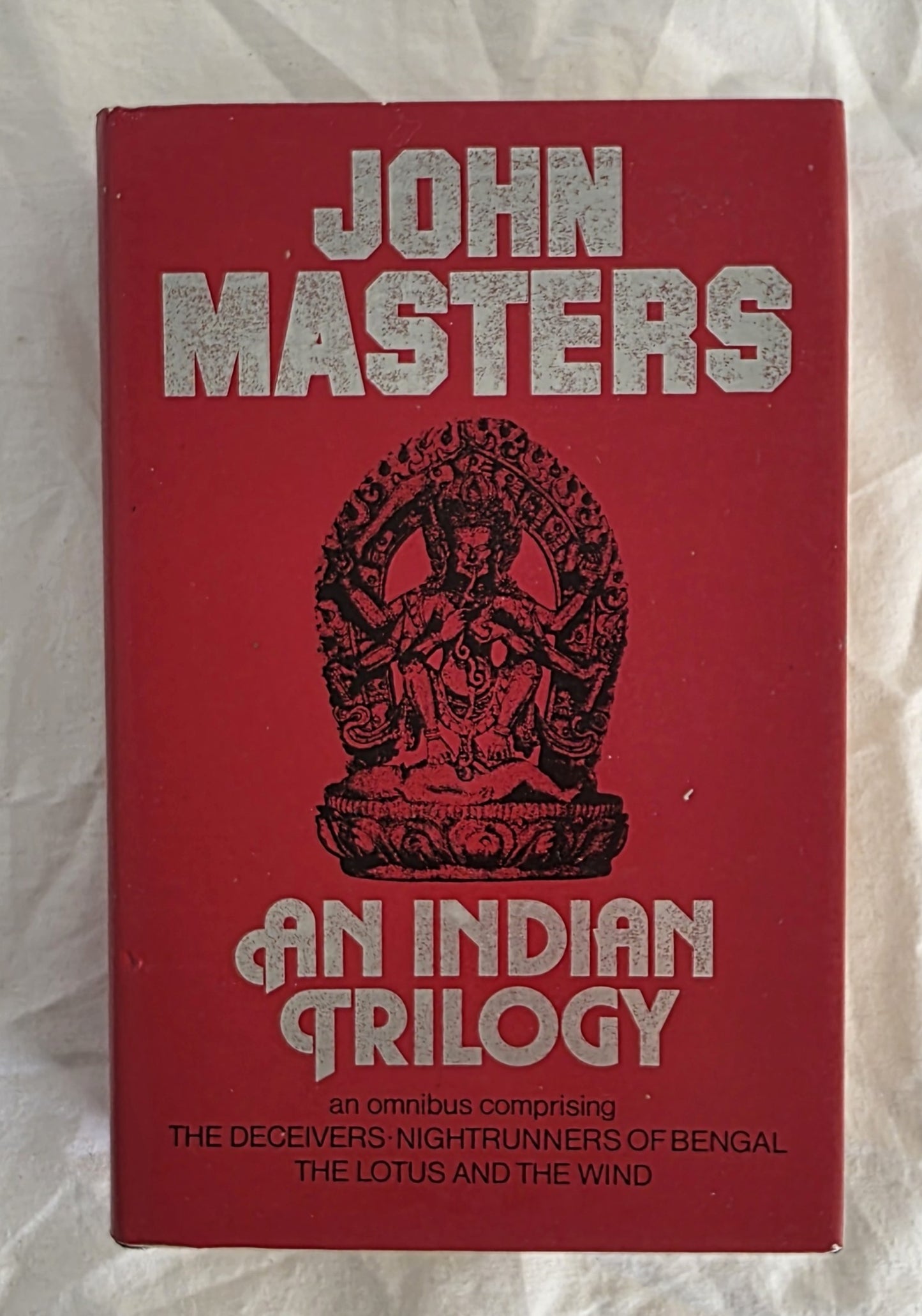 Red book cover with 'John Masters: An Indian Trilogy' on a textured white background