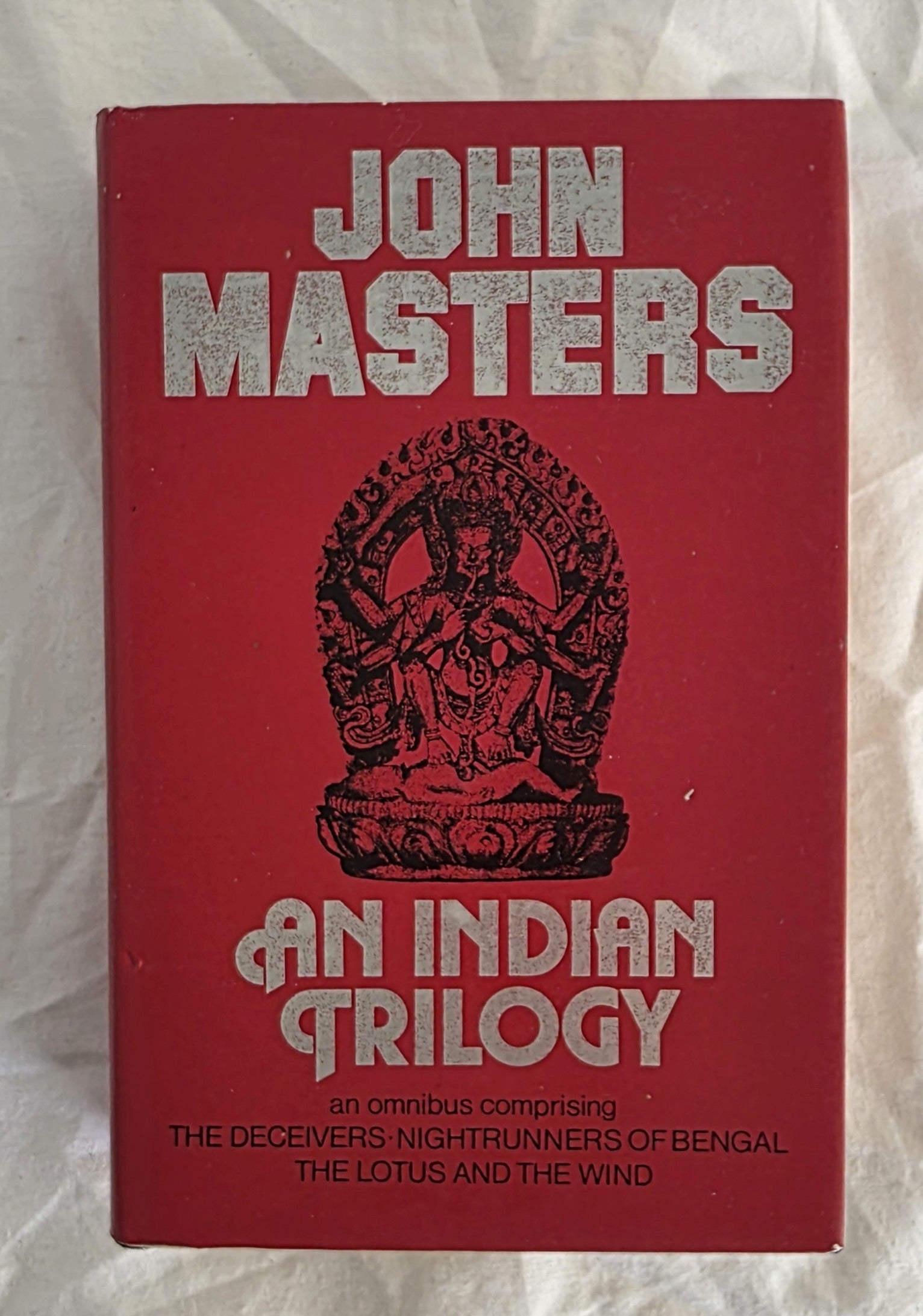 Red book cover with 'John Masters: An Indian Trilogy' on a textured white background