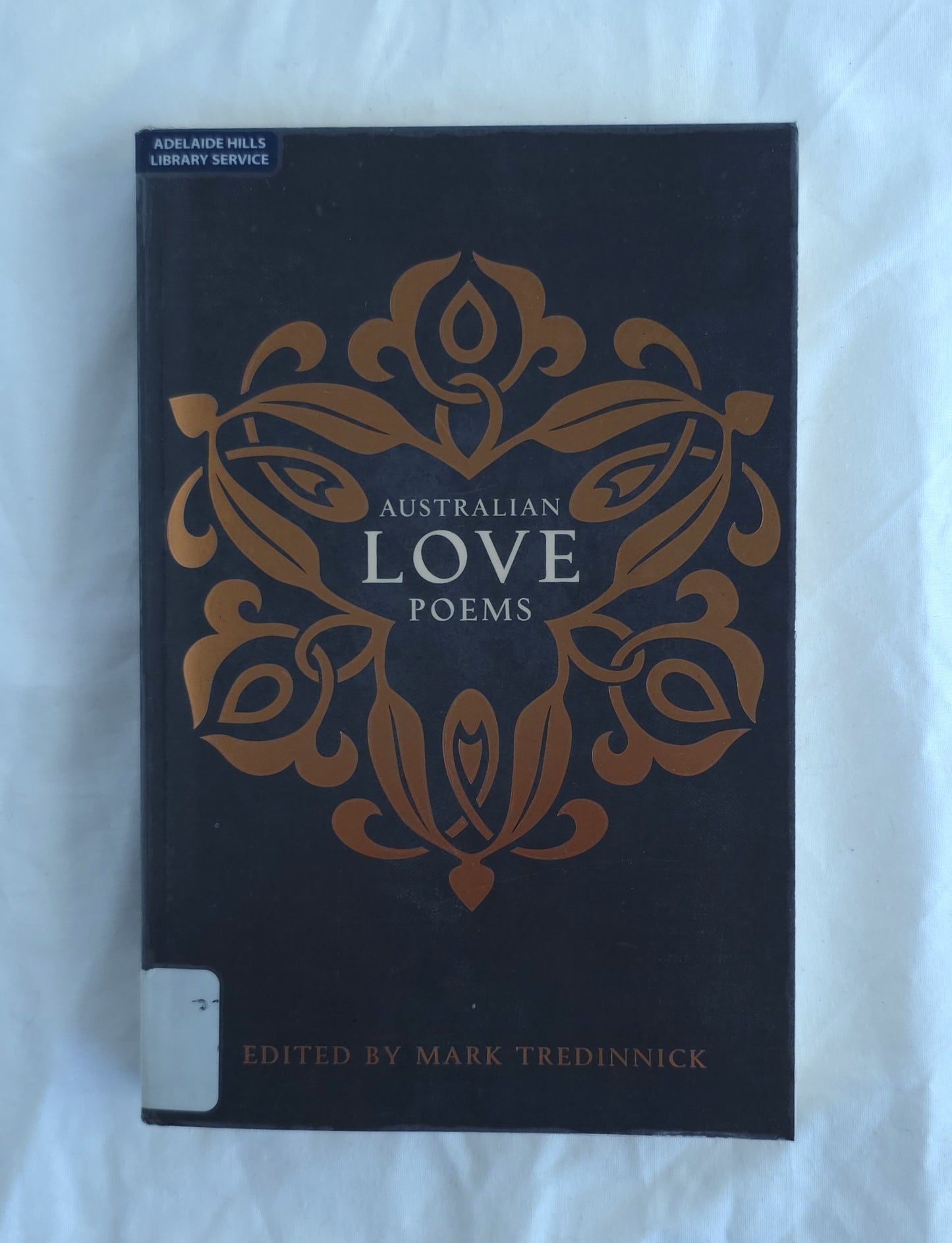 Book titled 'Australian Love Poems' with decorative cover on a white background