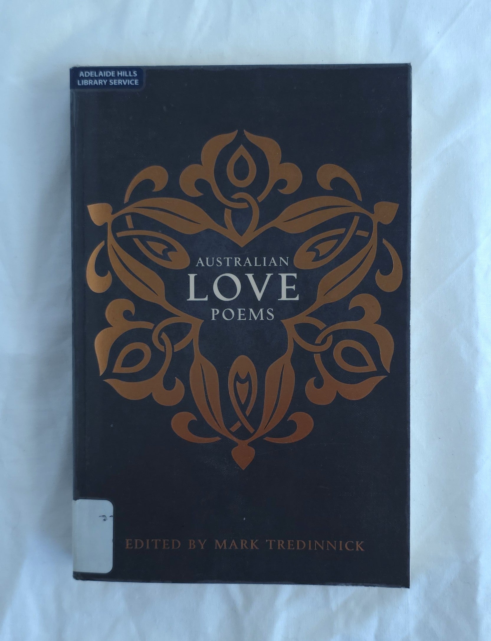 Book titled 'Australian Love Poems' with decorative cover on a white background