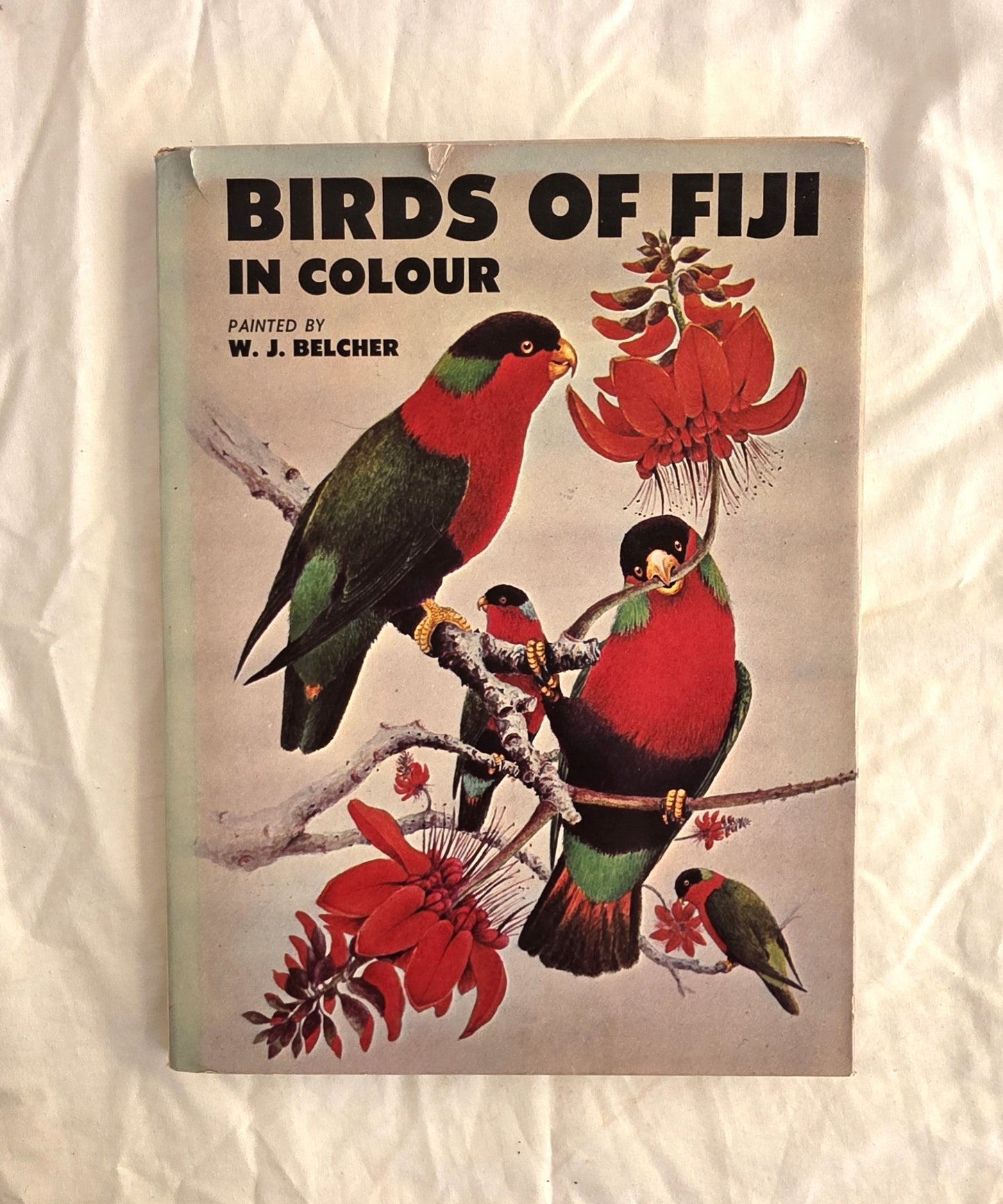 Book cover of 'Birds of Fiji in Colour' with illustrations of birds and flowers on a textured beige background.