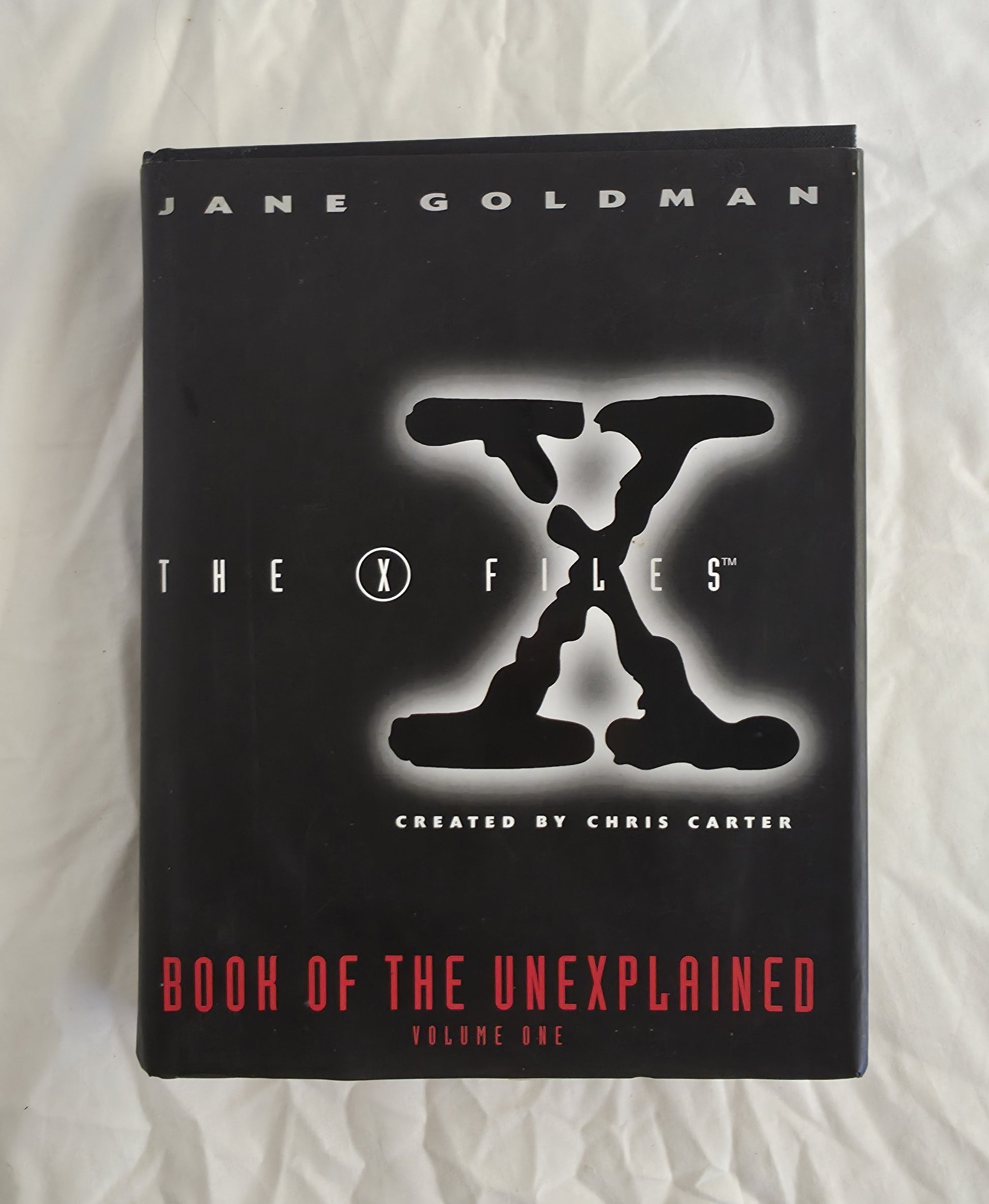 Book titled 'The X-Files Book of the Unexplained' by Jane Goldman on a white background