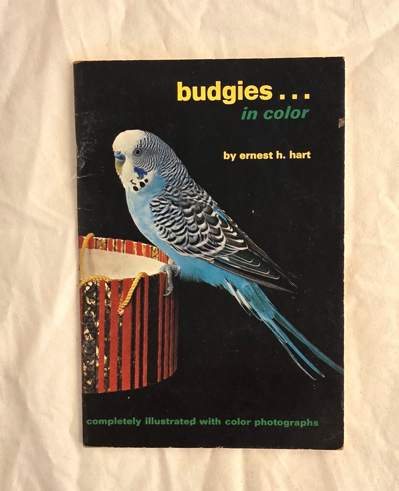 Book cover of 'Budgies in Color' by Ernest H. Hart with a parakeet illustration on a black background.