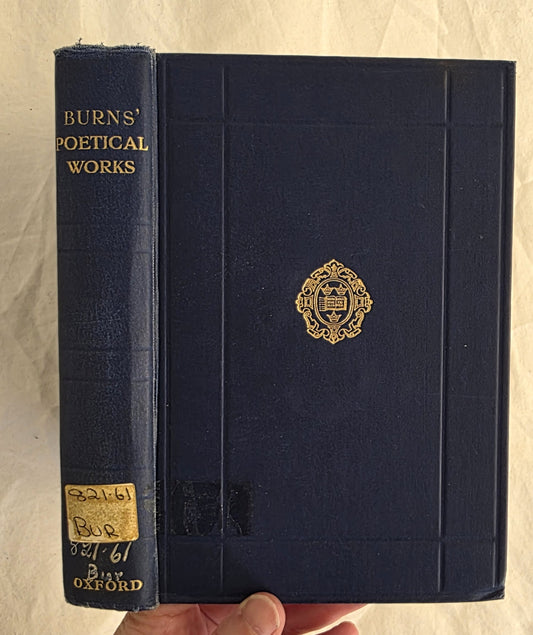 Blue book with gold embossed design and text on a beige background