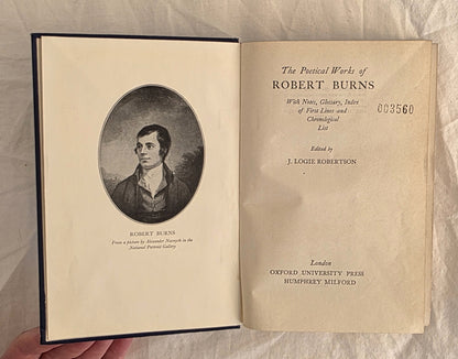 Open book showing the title page and portrait of Robert Burns on a textured beige background
