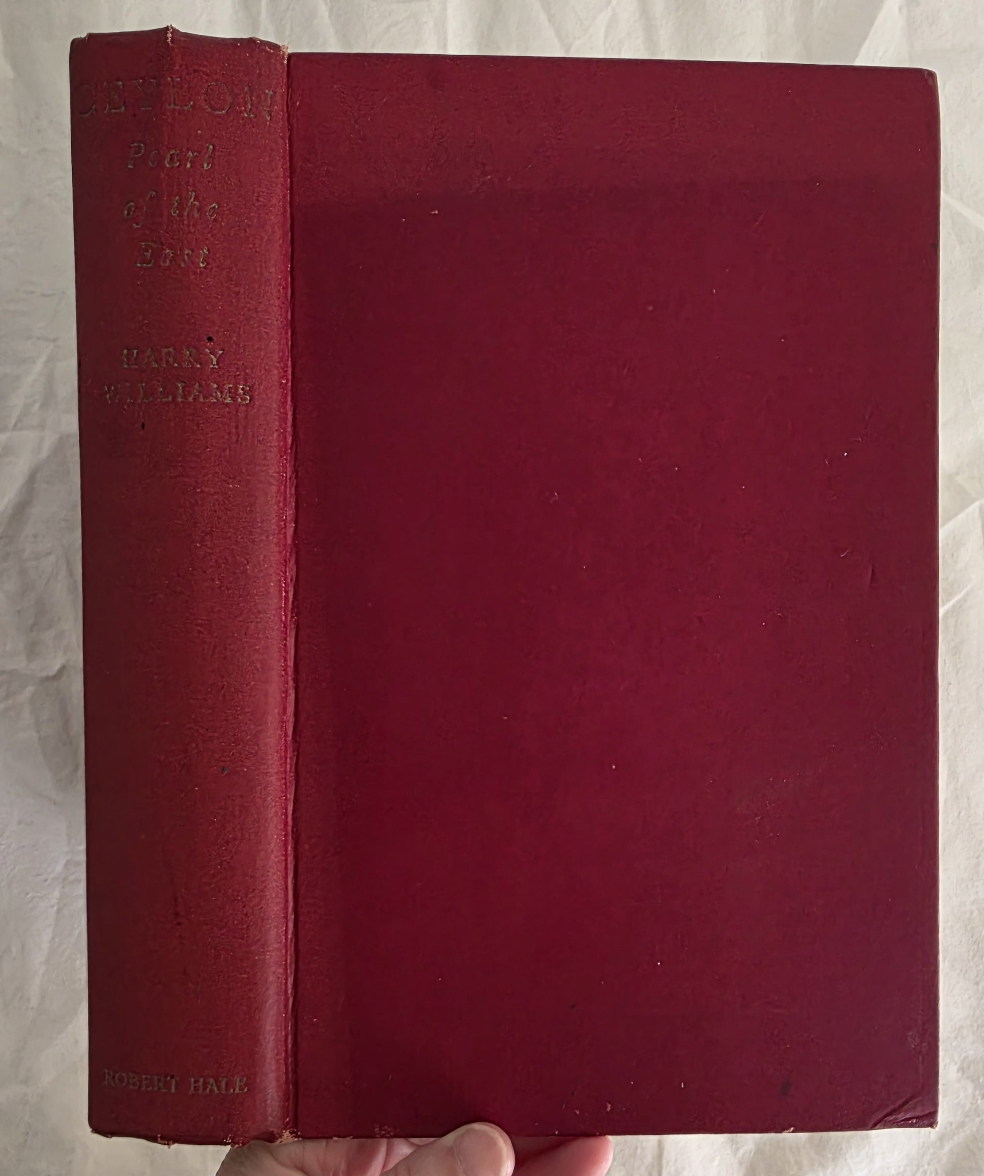 Red book held by a hand on a white background