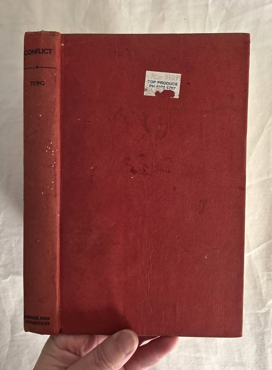 Red book held by a hand on a light fabric background