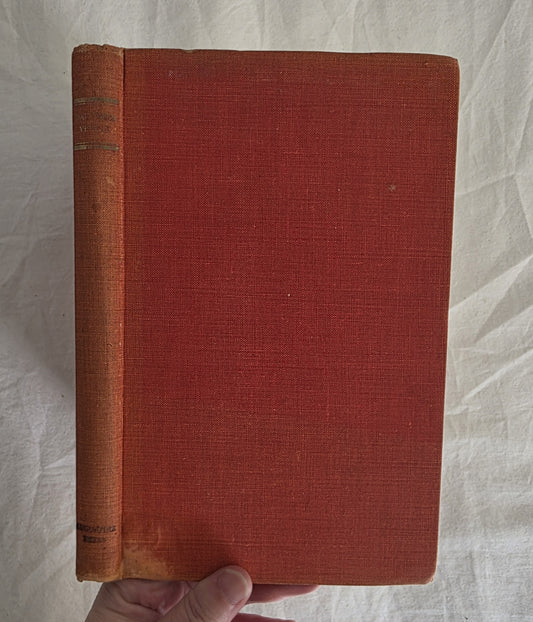 Red book held by a hand on a textured white background