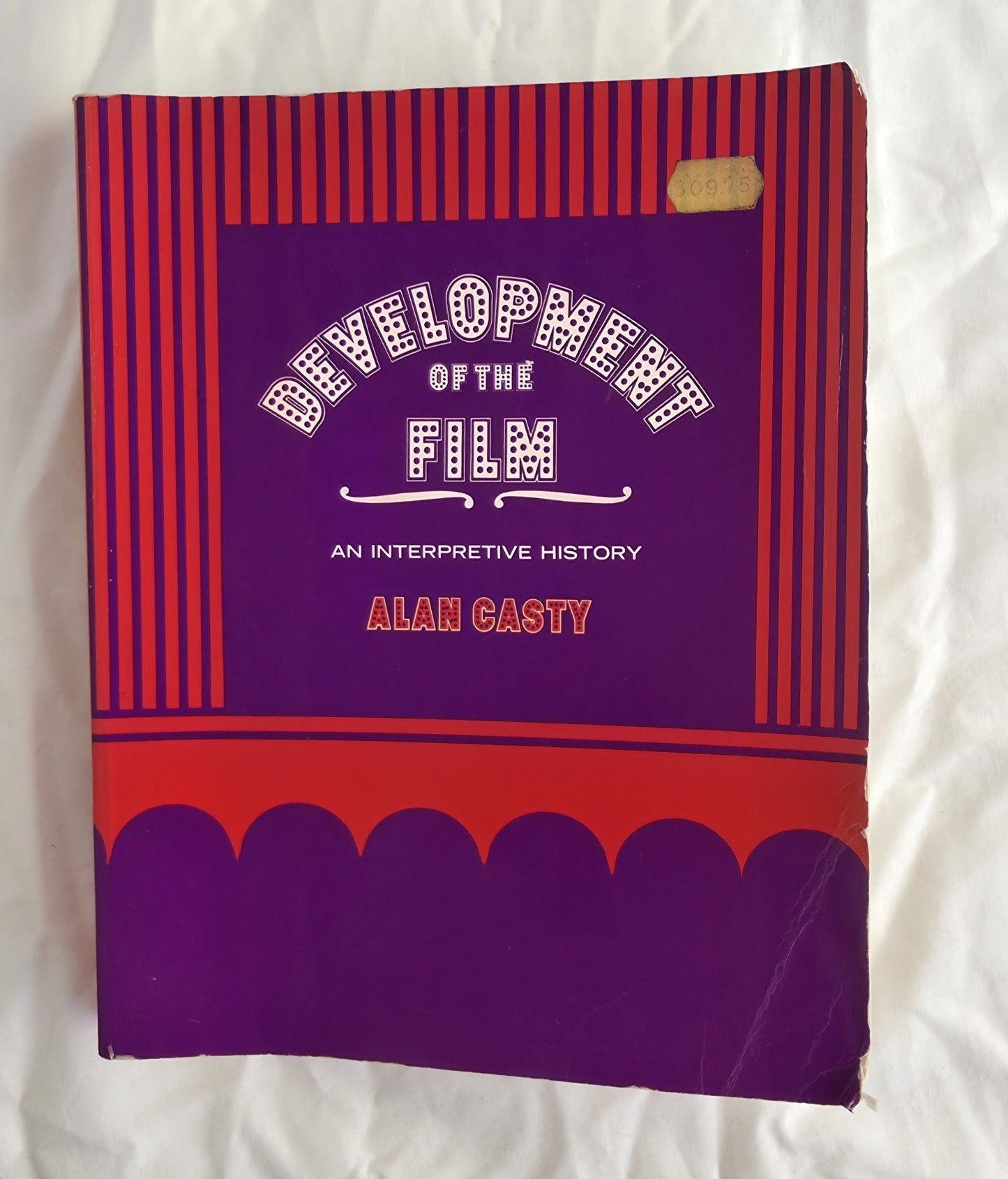 Book titled 'Development of the Film: An Interpretive History' by Alan Casty on a white background