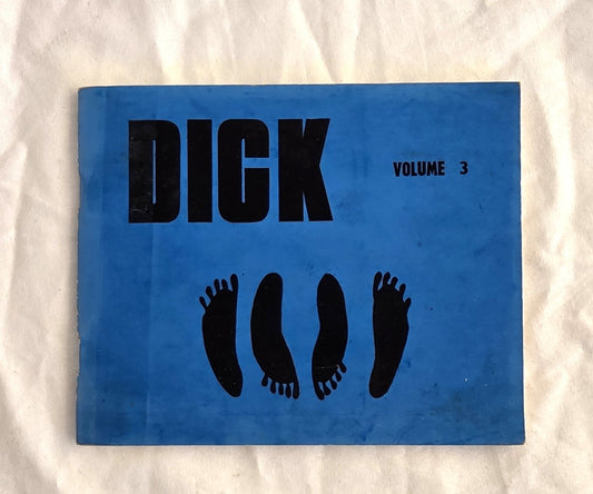 Blue book titled 'DICK Volume 3' with black text and footprints on a white textured background