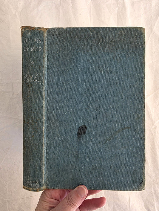 Vintage book with a blue cover held by a hand on a white background