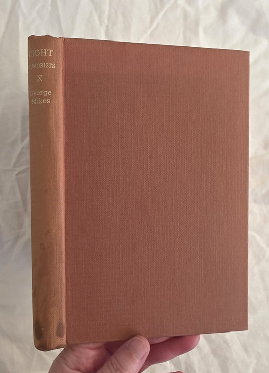 Brown book held by a hand against a white background