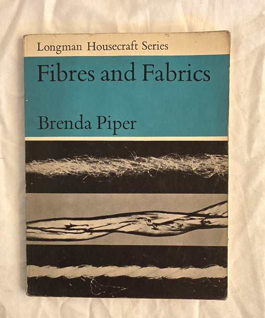 Book titled 'Fibres and Fabrics' by Brenda Piper from the Longman Housecraft Series on a textured white background.