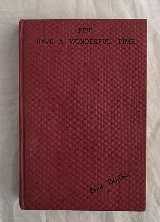 Red book with text 'Five Have a Wonderful Time' and signature on a textured surface