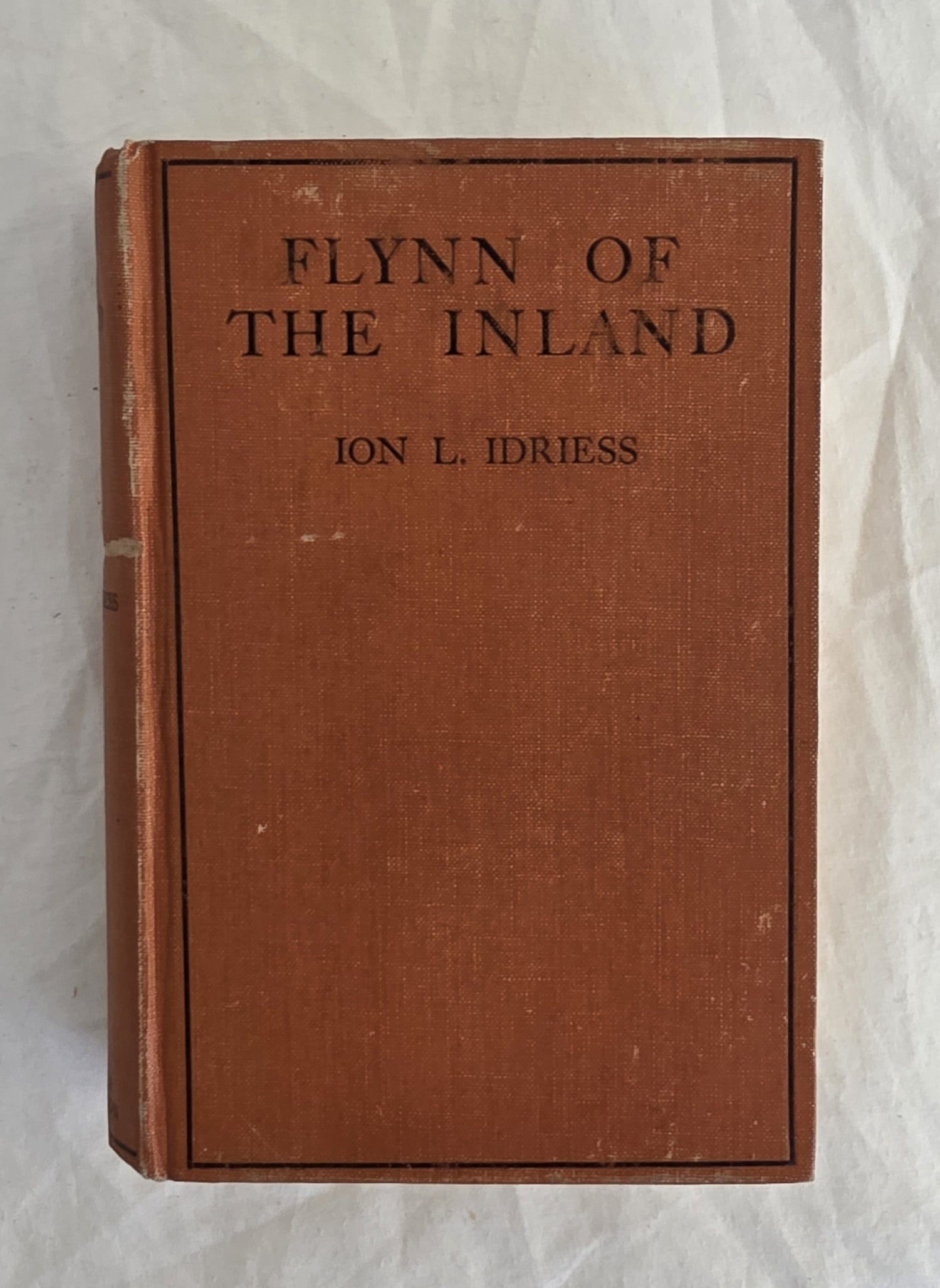 Vintage book titled 'Flynn of the Inland' by Ion L. Idriess on a textured white background