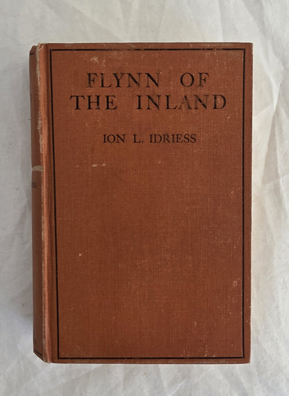 Vintage book titled 'Flynn of the Inland' by Ion L. Idriess on a textured white background