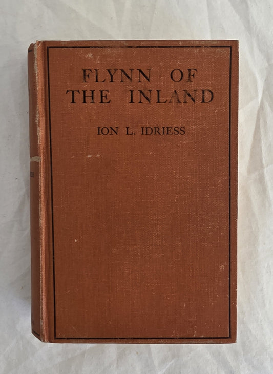 Vintage book titled 'Flynn of the Inland' by Ion L. Idriess on a textured white background
