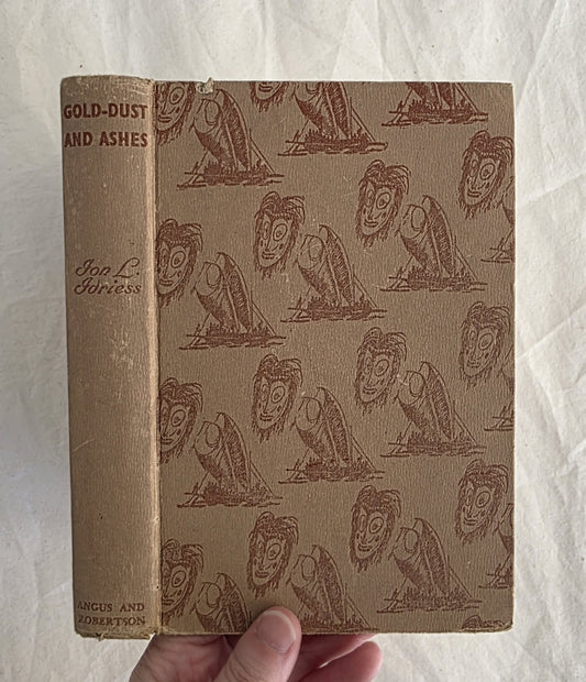 Vintage book with decorative cover held by a hand on a textured white background