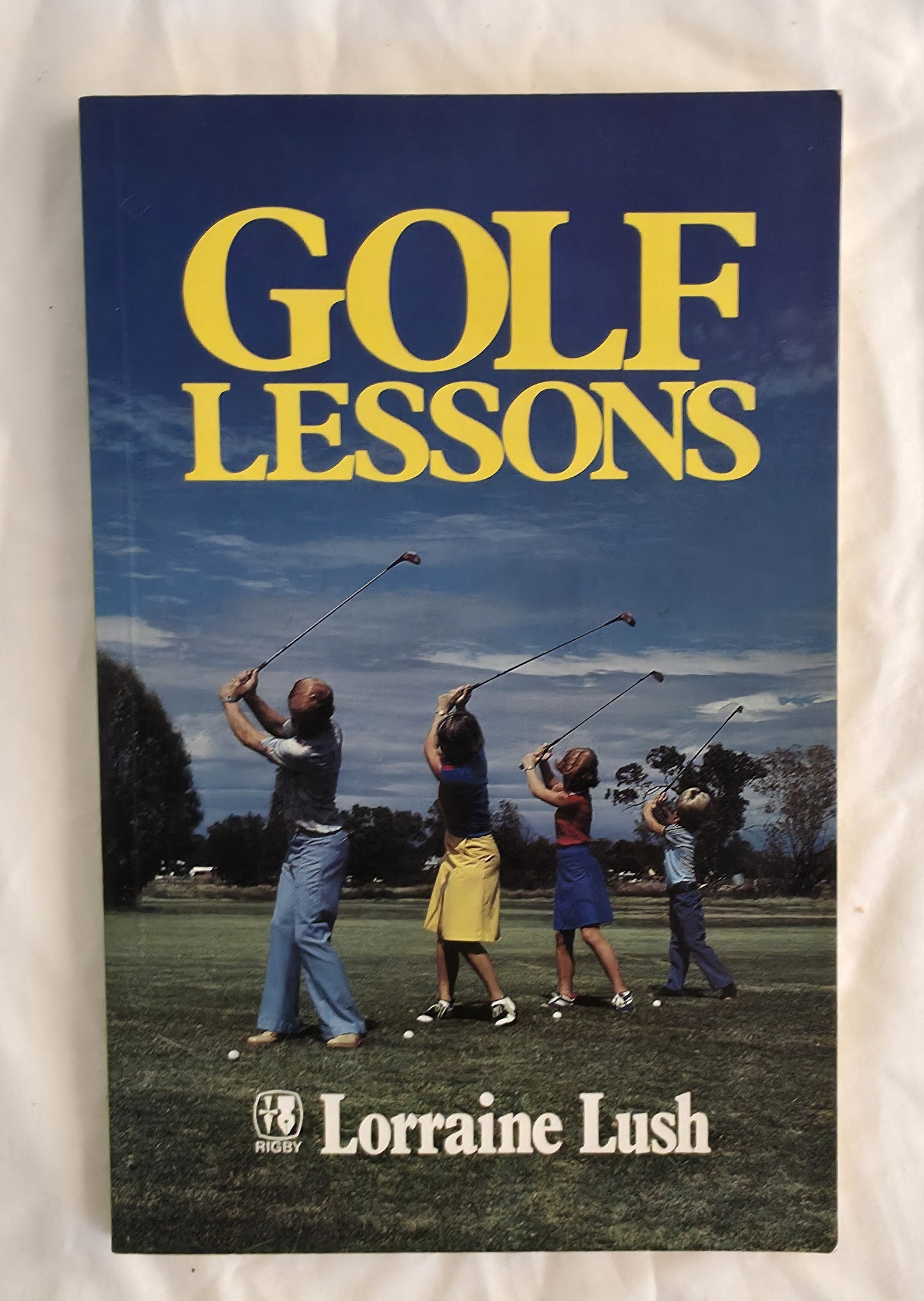 Book titled 'Golf Lessons' by Lorraine Lush with a cover showing people playing golf.