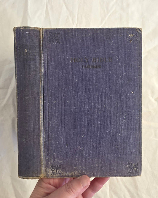 Vintage blue Bible held by a hand on a white background