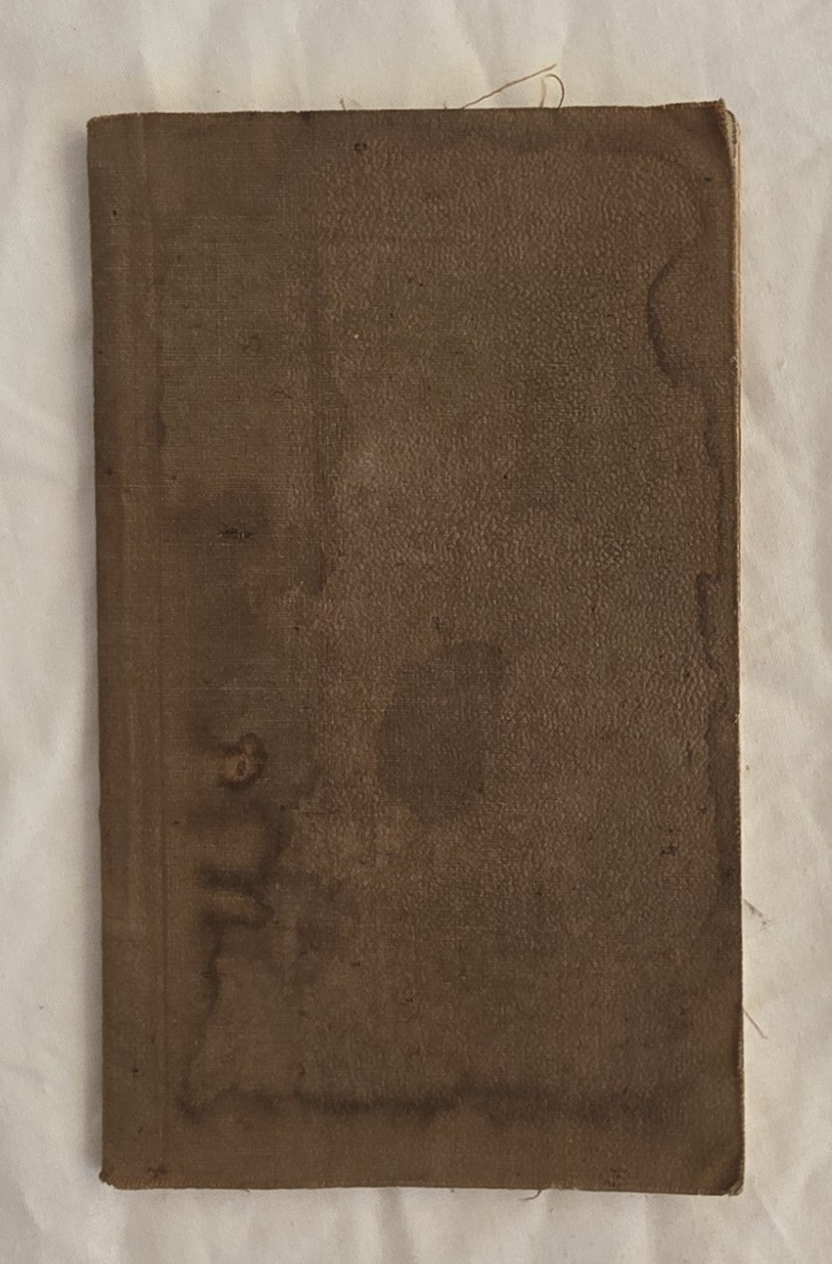 Brown leather-bound book with visible wear on a white background
