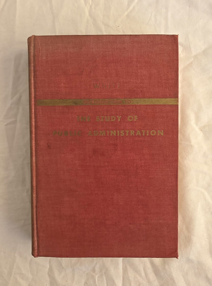 Red book with gold band and text on a beige background