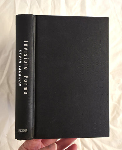 Black book titled 'Invisible Forms' by Kevin Jackson held against a light background