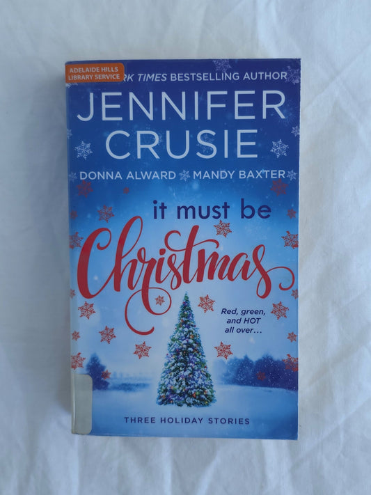 Book titled 'It Must Be Christmas' by Jennifer Crusie on a white background