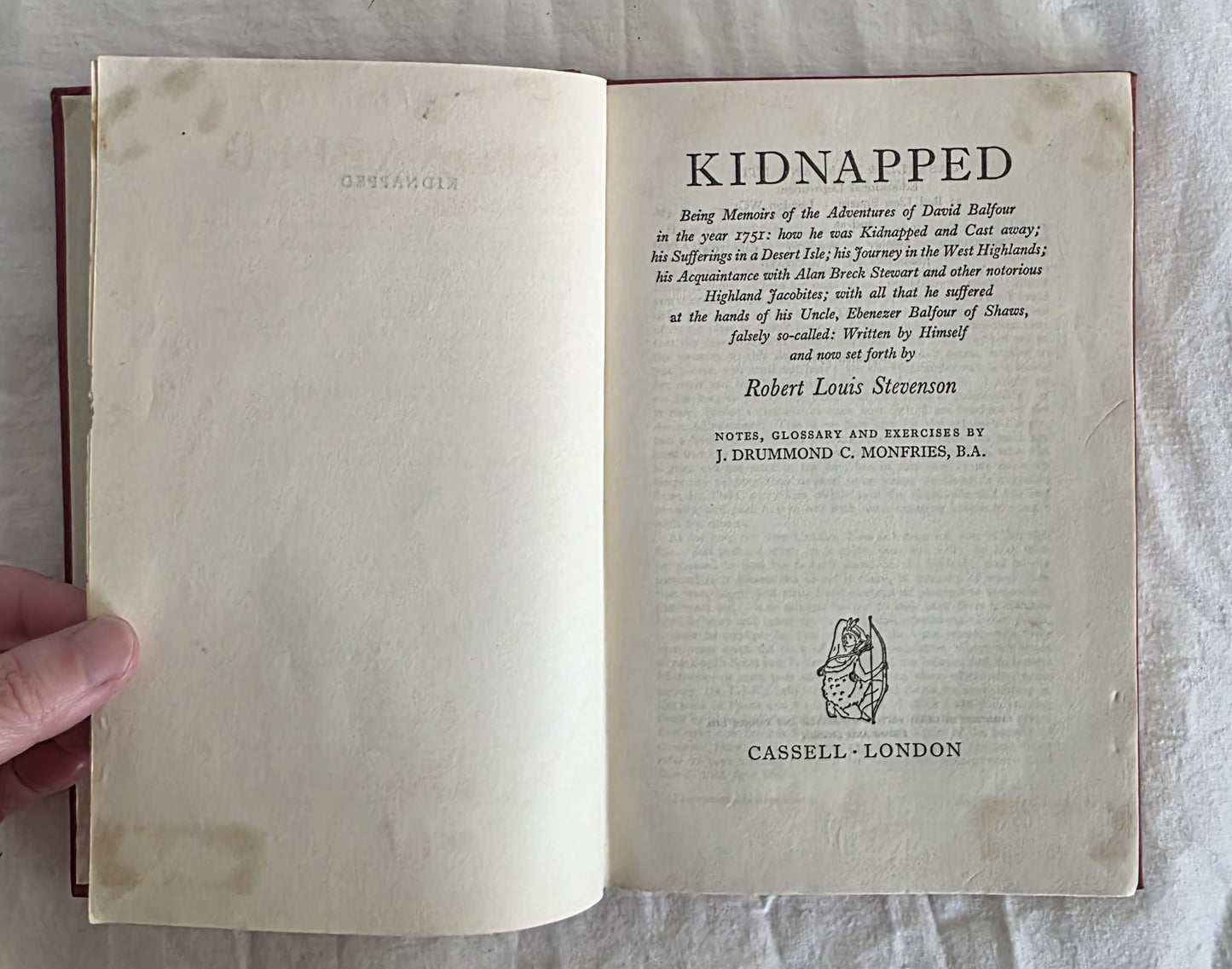 Open book showing the title page of 'Kidnapped' by Robert Louis Stevenson.
