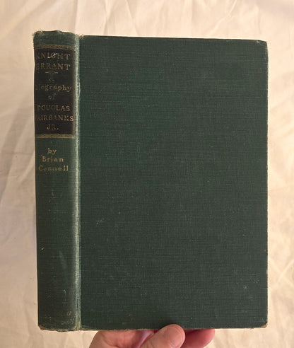 Green book held by a hand on a white background