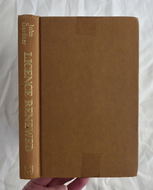 Brown book titled 'Licence Renewed' by John Gardner on a white background