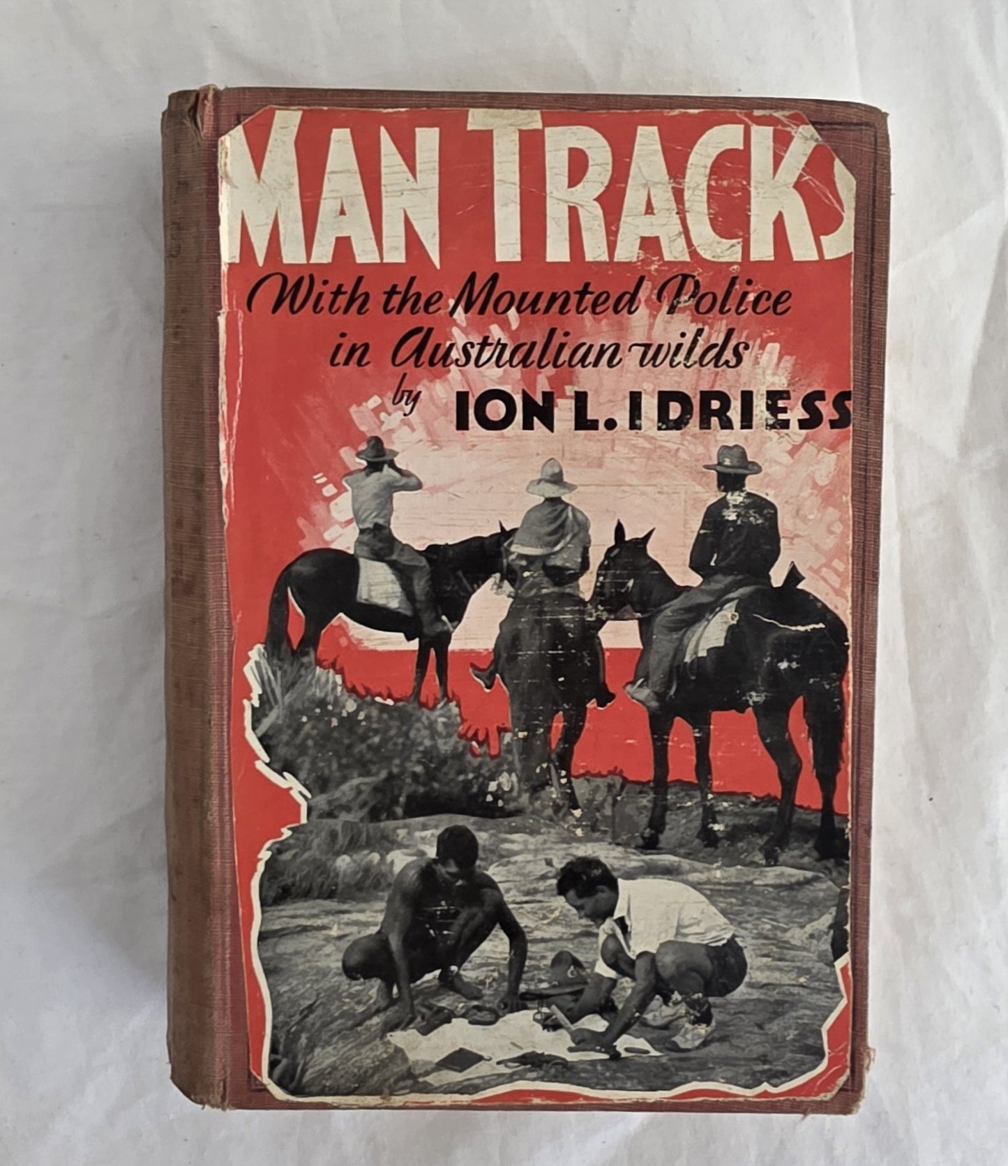 Book cover of 'Man Tracks' with mounted police and Aboriginal people in Australian wilderness, by Ion L. Idriess.