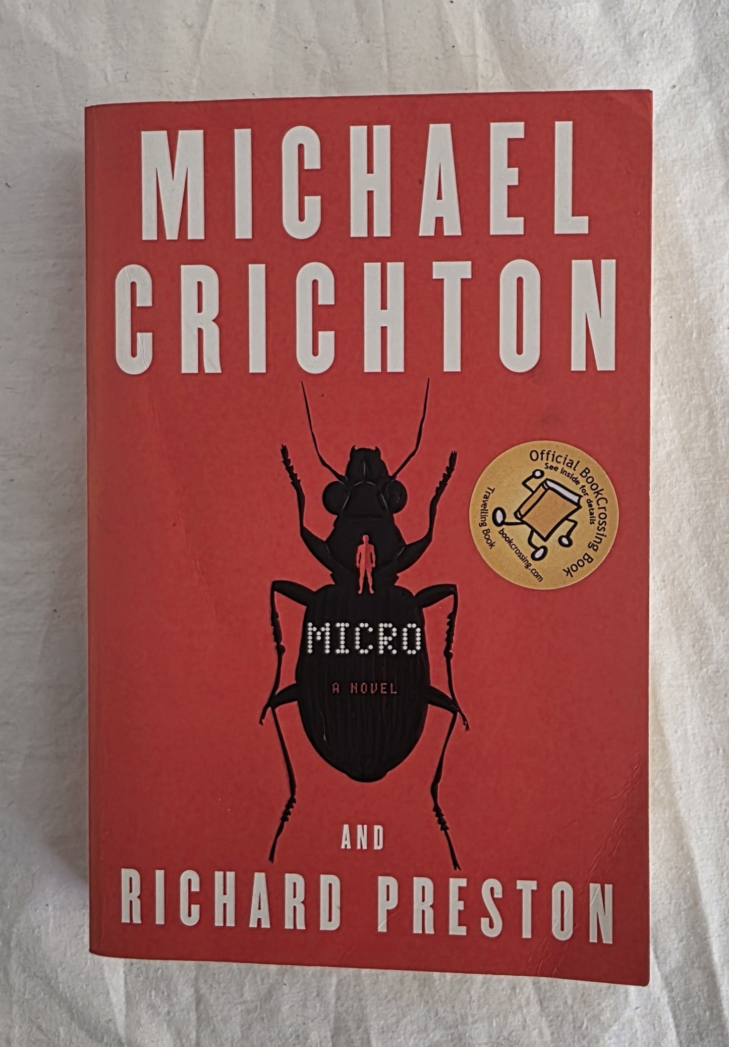 Book cover of 'Micro' by Michael Crichton and Richard Preston on a textured surface