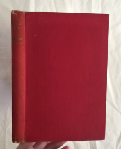 Red book held by a hand against a white background