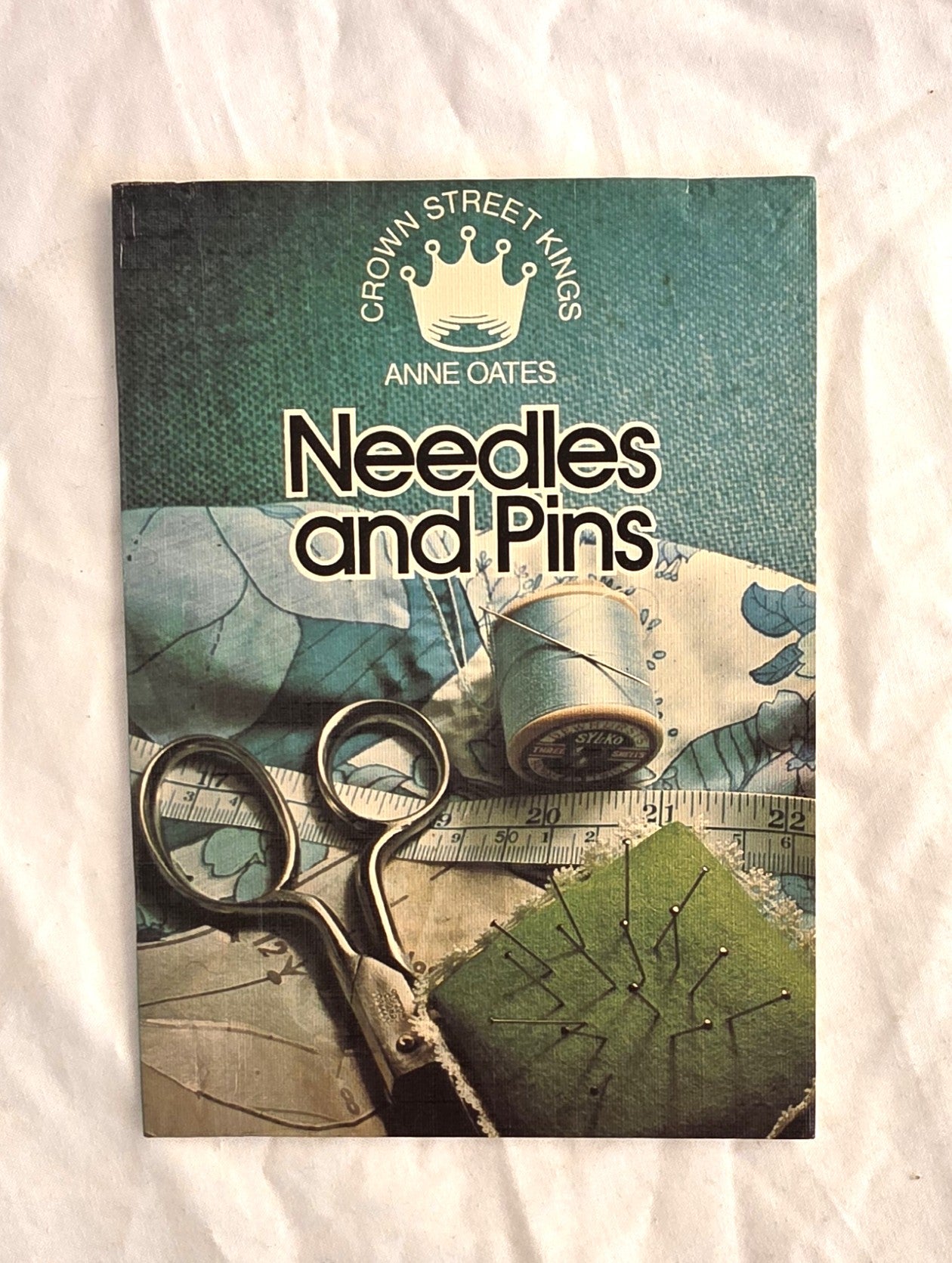 Book cover of 'Needles and Pins' by Anne Oates with sewing-themed design on a white background