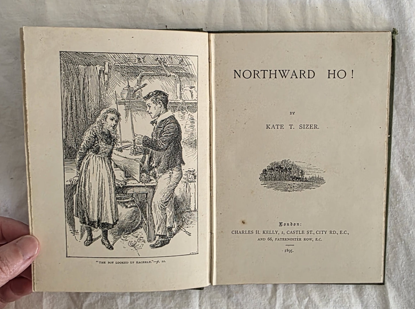 Open book titled 'Northward Ho!' by Kate T. Sizer, held by a hand on a textured surface.