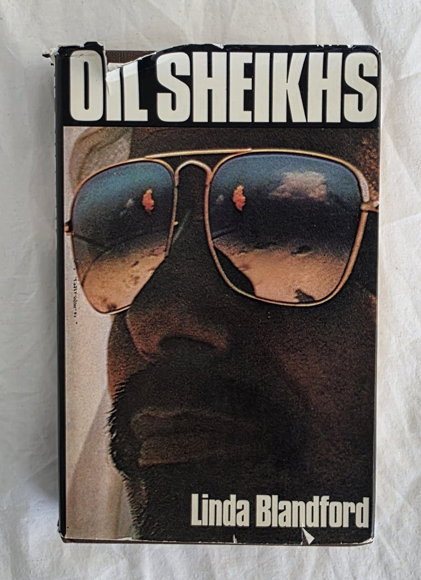 Book cover of 'Oil Sheikhs' by Linda Blandford with a person wearing sunglasses.