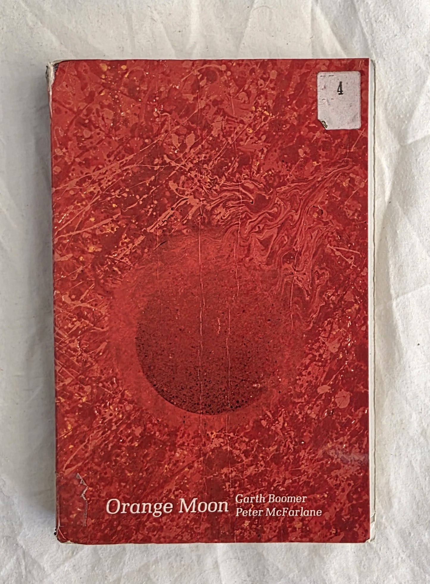 Red book titled 'Orange Moon' by Garth Boomer and Peter McFadlane on a textured white background
