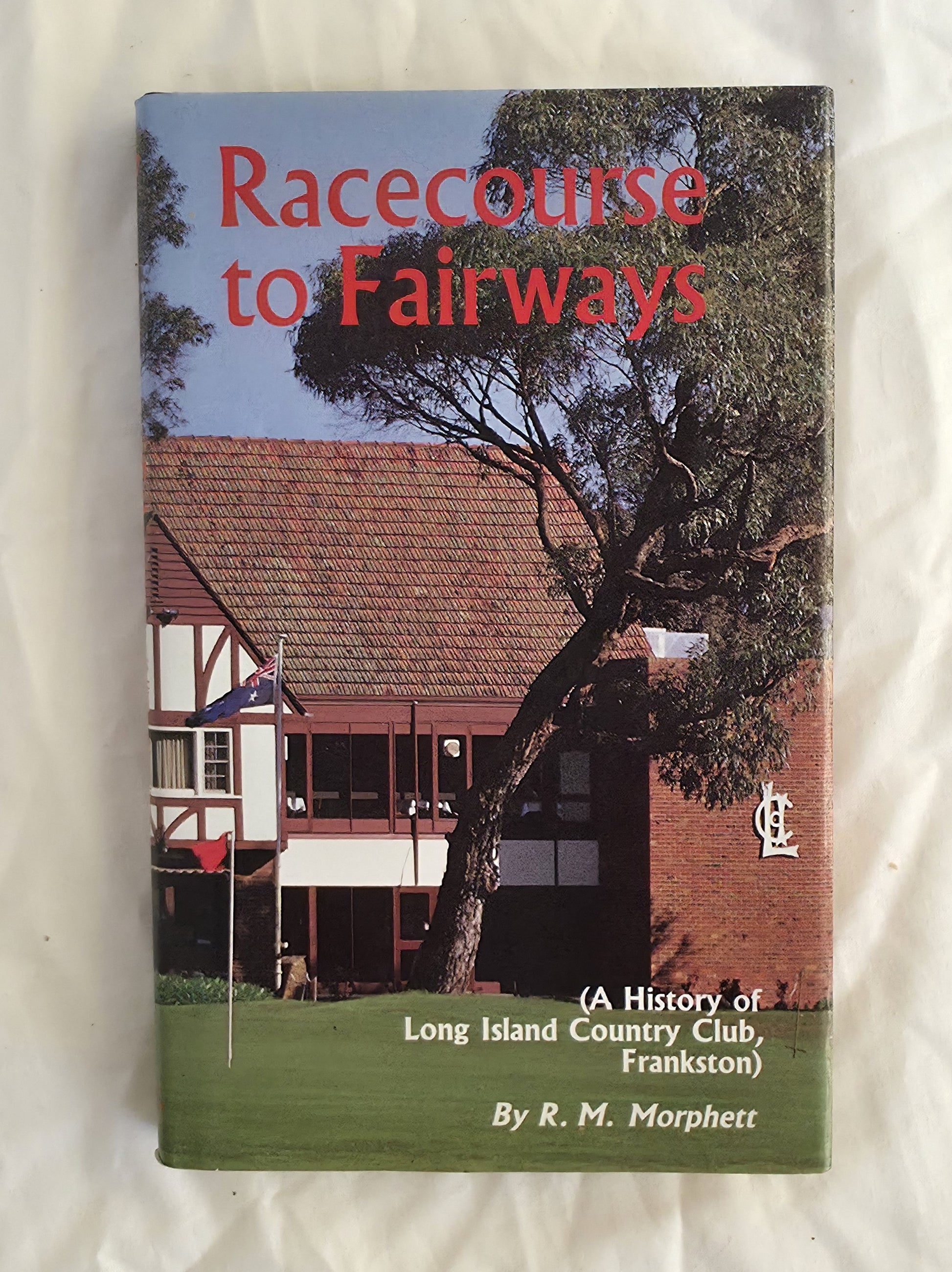 Book cover of 'Racecourse to Fairways' with a building and tree on the cover