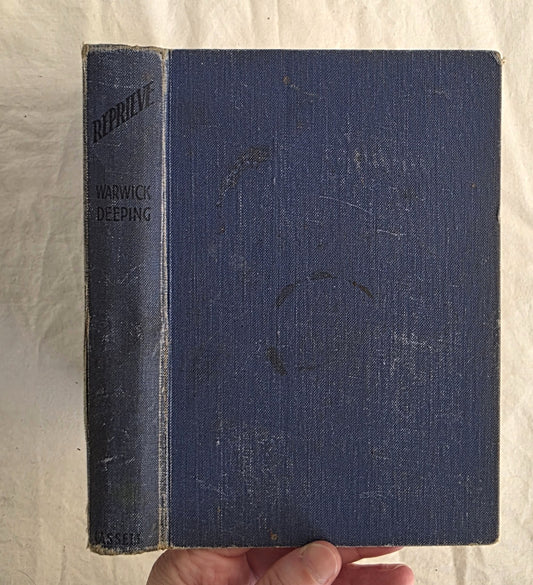 Vintage blue book held by a hand on a textured beige background