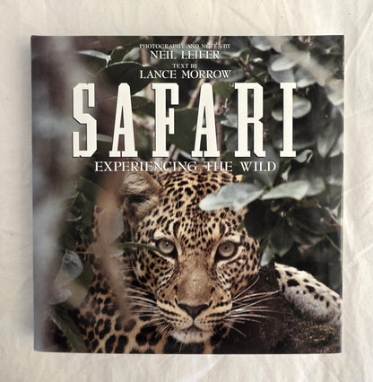 Book cover of 'Safari: Experiencing the Wild' with a leopard peeking through leaves.