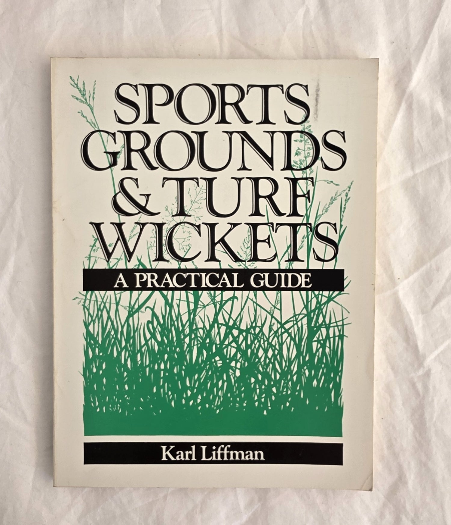 Book cover of 'Sports Grounds & Turf Wickets: A Practical Guide' by Karl Liffman on a textured beige background.