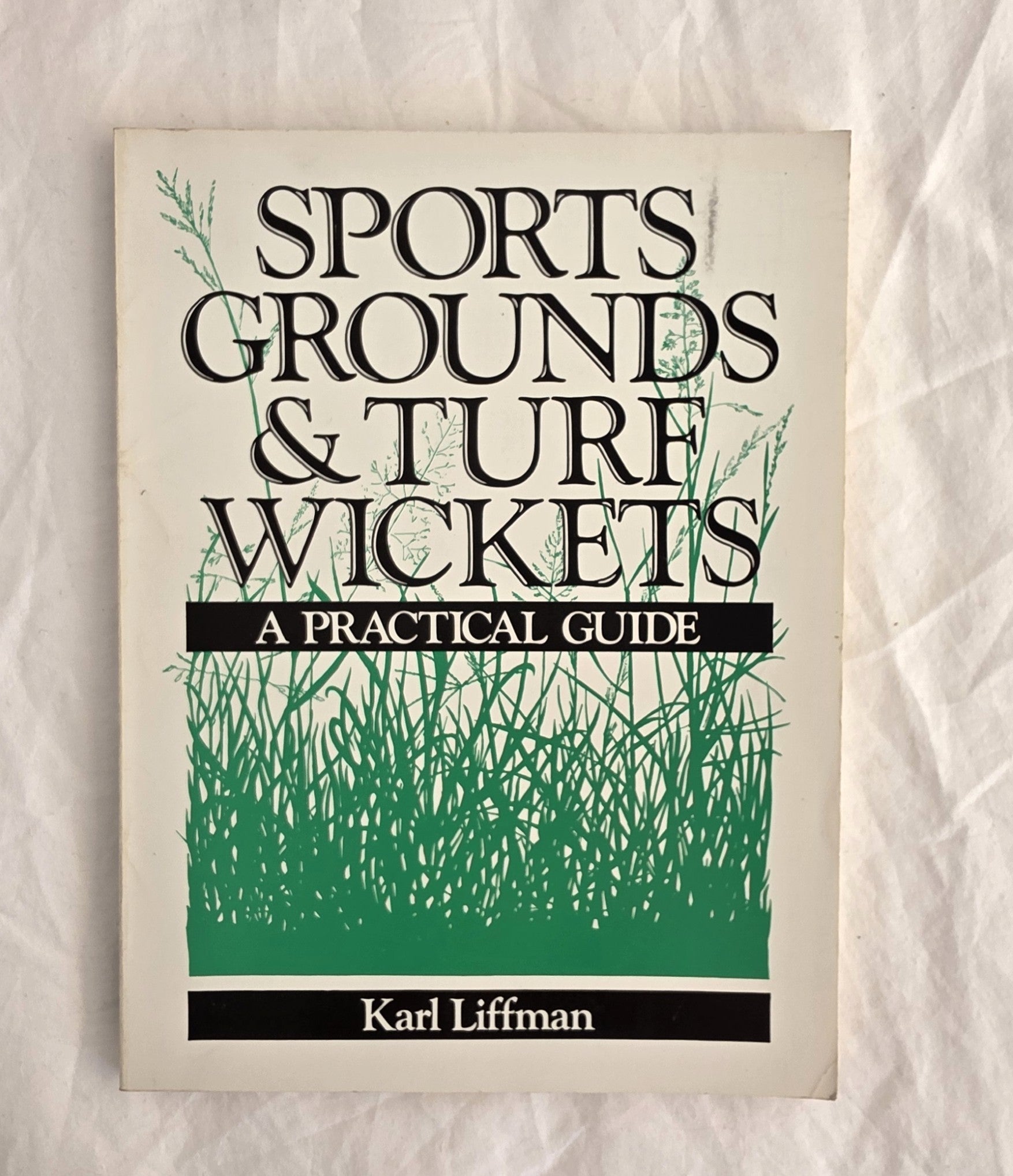 Book cover of 'Sports Grounds & Turf Wickets: A Practical Guide' by Karl Liffman on a textured beige background.