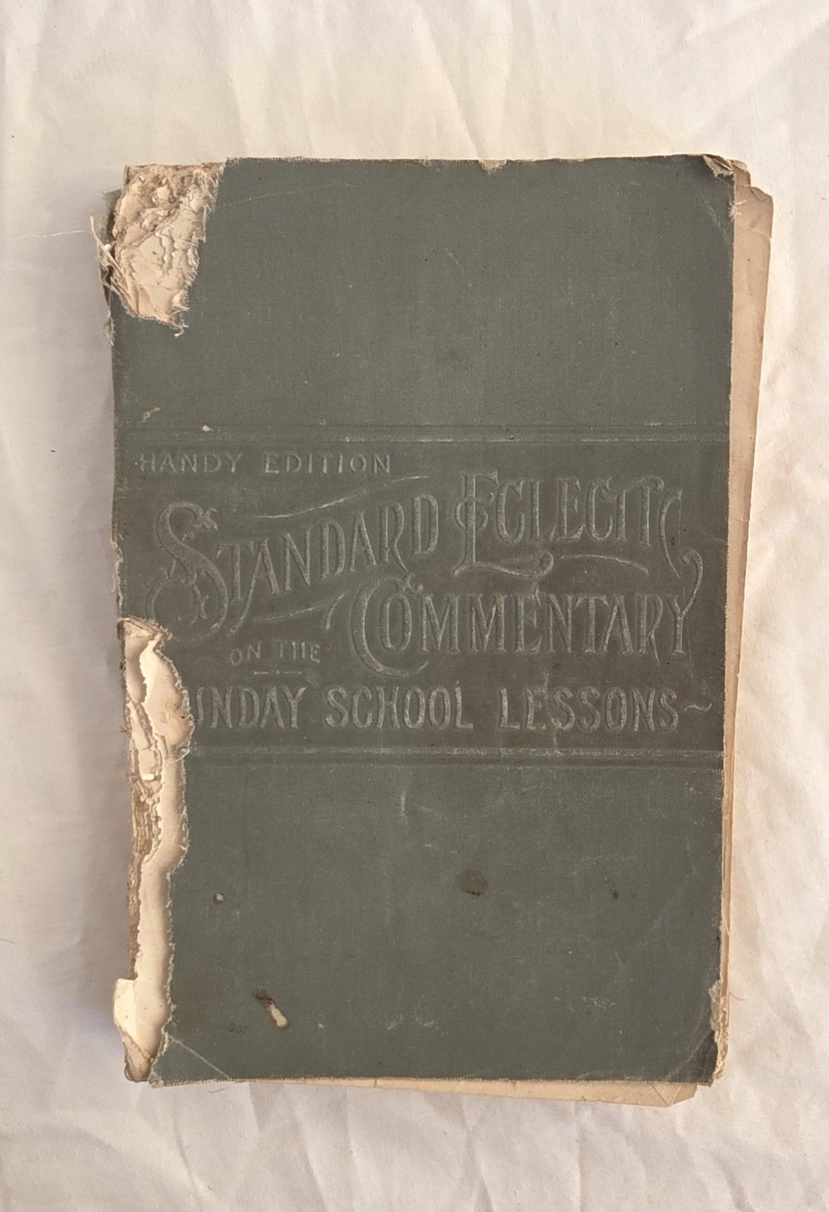 Vintage book titled 'Standard Eclectic Commentary on the Sunday School Lessons' with a worn cover.